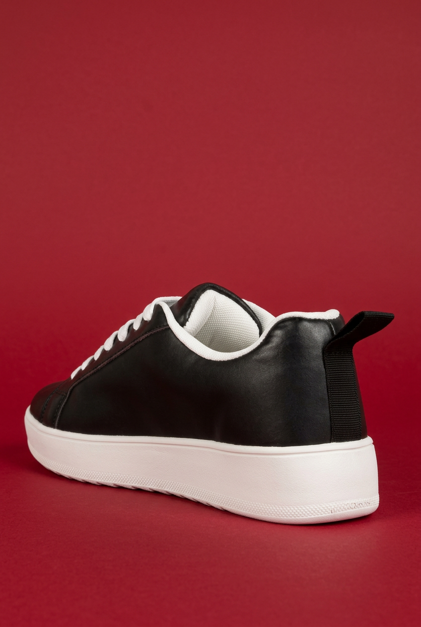 Black Rouxy sneaker rear angle on red background