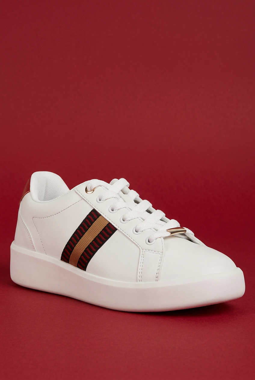 White sneaker angled view with red background